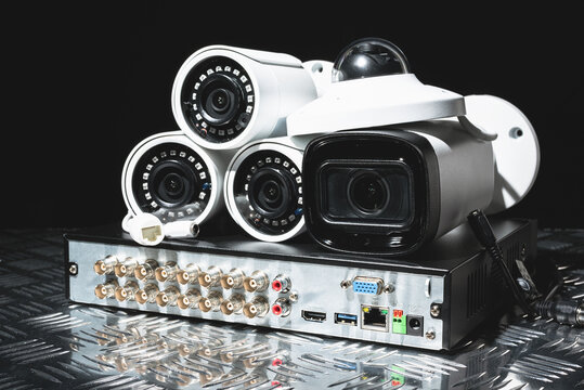 Modern white security cameras and video recorder close up. Video surveillance concept background.
