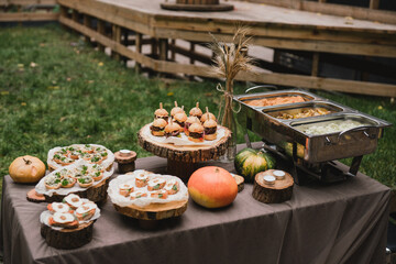 Catering banquet table at reception. Casual wedding party. Food styling, appetizers bar, welcome drink, event design.