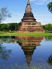 Fototapeta na wymiar Thai temple and its reflection into the calm water, Wat Mahathat, Sukhothai, Thailand