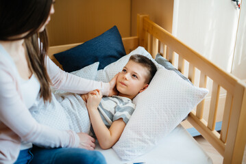 A mother takes care of her child who has a fever and fever. Disease and healthcare