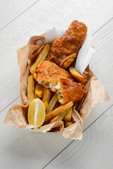 Fish and chips with lemon in greaseproof paper