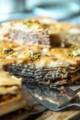 Homemade pistachio baklava triangles on wooden board.