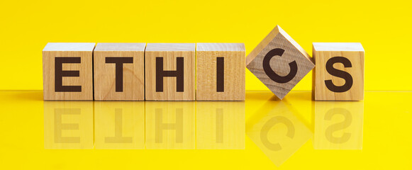 ethics word background on wood blocks, yellow background