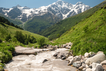 Fototapeta premium Turquoise water in mountain river on valley and glacier on background.