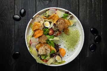 meat salad with vegetables, tomatoes, carrots on a white plate
