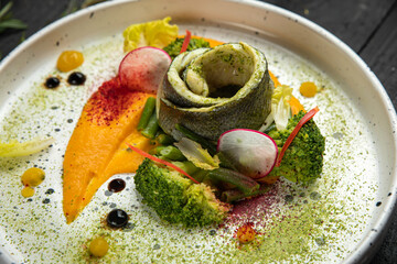 Sea fish cooked in a premium restaurant, with sauce and vegetable puree on a white trail
