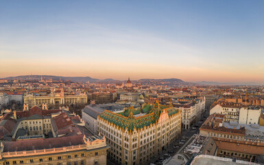 Aerial drone shot of art nouveau rooftop postal bank in Budapest dawn with Parliament view