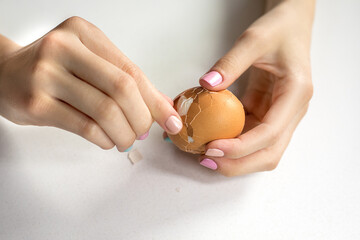 Photos of beautiful elegant women's hands with manicure that clean a boiled egg. Keto diet. Good nutrition. Healthy food. Farm