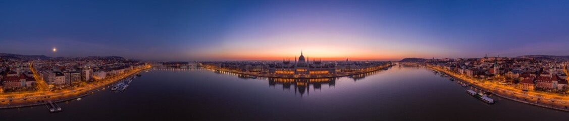 Fototapeta premium Panoramic aerial drone shot of Hungarian Parliament lights off sunrise in Budapest dawn