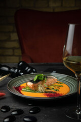 Grilled salmon with pumpkin puree. with cooked vegetables
