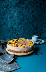 Homemade chocolate mousse cake with cumquats on blue background.