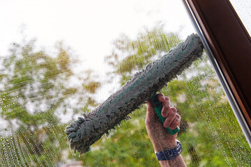 laveur de vitres nettoyant la fenêtre d'une maison 