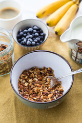 Making breakfast. Homemade granola with nuts, dark chocolate, bilberries and milk.