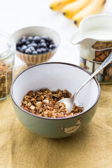 Making breakfast. Homemade granola with nuts, dark chocolate, bilberries and milk.