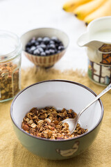 Making breakfast. Homemade granola with nuts, dark chocolate, bilberries and milk.