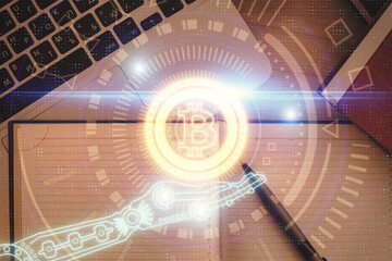 Blockchain theme hologram drawings over computer on the desktop background. Top view. Double...