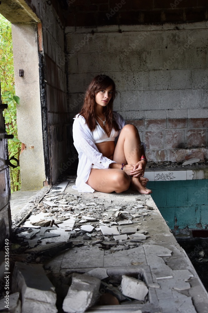 Wall mural Jeune femme assise dans une vieille cuisine