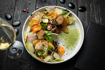 meat salad with vegetables, tomatoes, carrots on a white plate
