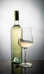 Bottle of White Wine and a Glass with Swirled Wine