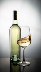 Bottle of White Wine and a Glass with Swirled Wine