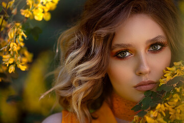 Naklejka premium Portrait of a Pretty sensual woman on a background of a yellow blossom tree. Summer time, summer colors.