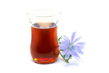 Chicory drink in glass cup with blue flower.