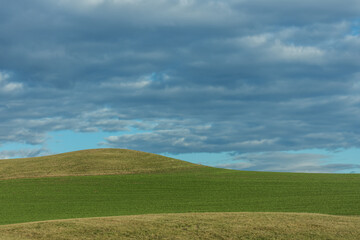 green landscape with hills and clouds