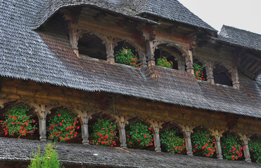 Barsana Monastery, Maramures, Romania, Europe, Summer 2018. Wooden building with red geraniums...