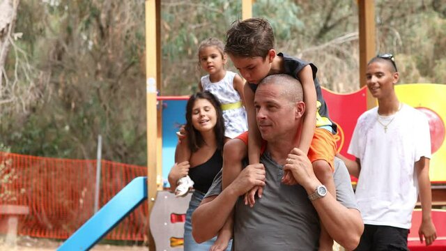 Video in 4k di una famiglia mista tra Italiani e brasiliani che si muove in un parco