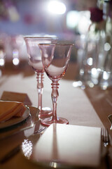 Served table in pink colors. Glasses for wine and champagne. A gala dinner at a wedding in a...