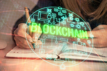 Double exposure of woman hands typing on computer and crypto market theme hologram drawing....