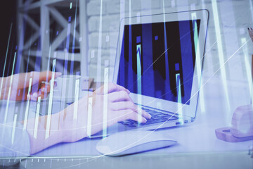 Double exposure of woman hands typing on computer and forex chart hologram drawing. Stock market...