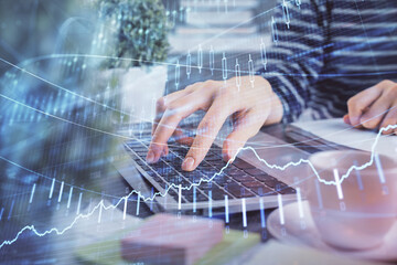 Double exposure of woman hands typing on computer and forex chart hologram drawing. Stock market invest concept.