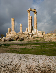 Fototapeta na wymiar View of the ruins of the temple of Hercules on the top of the mountain of the Amman citadel against the background of a dramatic sky with clouds