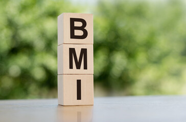 Acronym BMI - Body Mass Index. Wooden cubes with letters on table. Concept image.