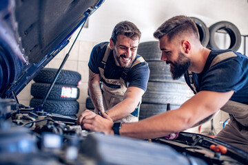 Auto mechanics check the oil in the engine.