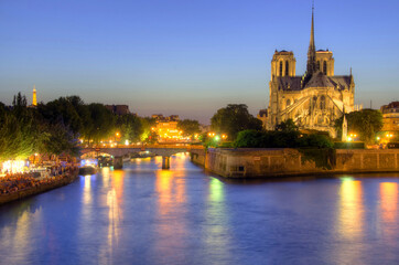 Notre Dame cathedral and seine river at dusk in Paris, France.