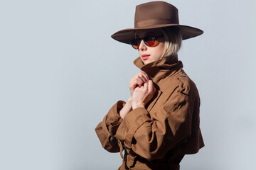 Fototapeta premium Style woman in cloak, hat and sunglasses on grey background
