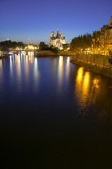 Notre Dame cathedral and seine river at dusk in Paris, France.