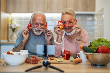 Senior couple recording video for their food blog at kitchen