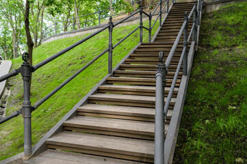 Fototapeta na wymiar wooden steps with metal railing in a pedestrian park