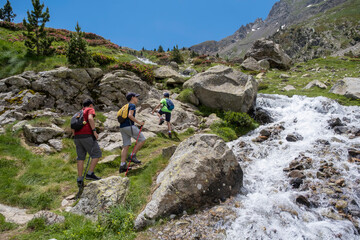 children climbing a mountain next to a river in the pyrenees