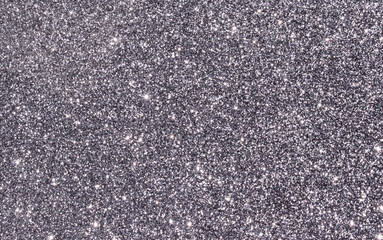 Silver, gray and black abstract glitter background with rough grain and shiny shimmering light reflections. Image is blank with room for text. Great for backdrop, textile, poster, textures, banners.