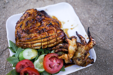 Grilled Squid Cuttlefish on a white plate is very tasty. Squid BBQ Grill at street food, Thailand.