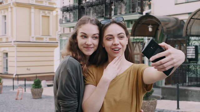 Two girls friend making selfie using phone with different emotions