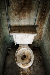 A very dirty abandoned toilet in a bathroom