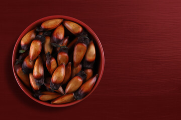 Pinion, traditional Brazilian food, Araucaria seed. Top view on colorful wooden background