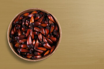 Pinion, traditional Brazilian food, Araucaria seed. Top view on colorful wooden background
