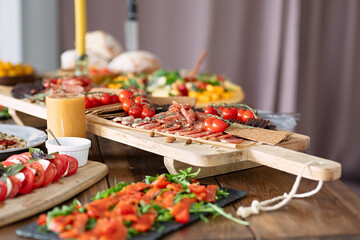 tasty and healthy food lies on  table, fish and vegetables are beautifully sliced, beautiful dishes on  wooden table, selective focus, festive dinner