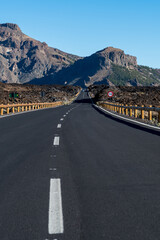 A long road between volcanoes, craters and mountain peaks on the teide on the island of tenerife in spain with clear blue skies